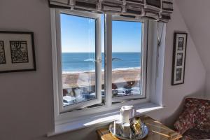 a room with a window with a view of the ocean at Mariners Hotel in Seaton