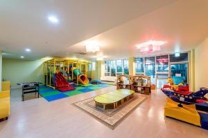 una sala de estar con una sala de juegos con un parque infantil en The Four Grace Resort en Seogwipo