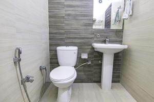 a bathroom with a toilet and a sink at FabHotel City Palace in Dehradun