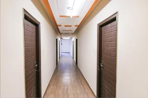 a hallway with two brown doors and a wooden floor at FabHotel City Palace in Dehradun
