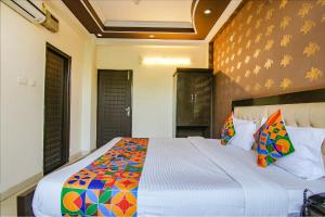 a bedroom with a large bed with a colorful comforter at FabHotel City Palace in Dehradun