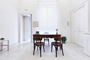 Casa di Lo Suites في ليتشي: غرفة طعام مع طاولة وكراسي خشبية