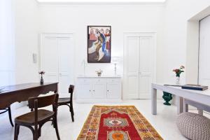 Cette chambre blanche dispose d'un bureau, d'une table et de chaises. dans l'établissement Casa di Lo Suites, à Lecce