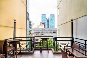 a balcony with tables and chairs and a view of a city at Grandma Lu Saigon Hostel - Japan Town in Ho Chi Minh City