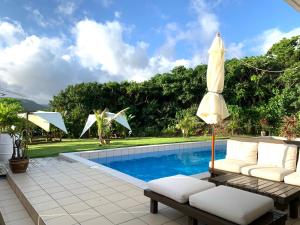 - un parasol installé sur une terrasse à côté de la piscine dans l'établissement NEST Iriomote, à Iriomote