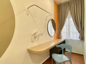 a bathroom with a desk and a chair and a mirror at MOON HOTEL in Brinchang