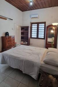 a bedroom with a large bed and a dresser and a window at Betuah Say [2BR City Center Holiday Home] in Tanjungkarang