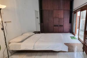 1 dormitorio con 1 cama grande con sábanas blancas en Betuah Say [2BR City Center Holiday Home] en Tanjungkarang