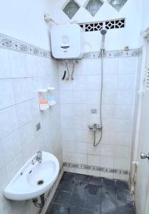a white bathroom with a sink and a shower at Betuah Say [2BR City Center Holiday Home] in Tanjungkarang