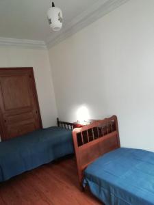 a bedroom with two beds and a door and a lamp at Appartement à 5 min à pied du centre ville et des sentiers, 6 personnes et 2 SDB in Fraize