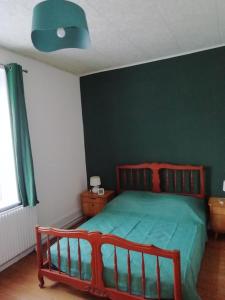 a bedroom with a bed with a green wall at Appartement à 5 min à pied du centre ville et des sentiers, 6 personnes et 2 SDB in Fraize