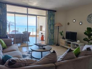 a living room with a couch and a tv at Santorini 206B -Margate RSA in Margate