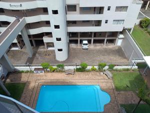 an overhead view of a swimming pool in front of a building at Santorini 206B -Margate RSA in Margate