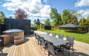 una terrazza in legno con tavolo, sedie e griglia di 4 Bedroom Gorgeous Home In Vggerlse a Bøtø By