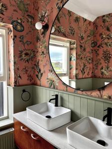 a bathroom with two sinks and a mirror at Contemporary yet cosy and characterful home in rural village setting in Kilfenora