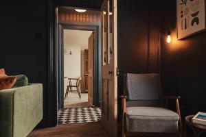 een woonkamer met een stoel en een deur bij Contemporary yet cosy and characterful home in rural village setting in Kilfenora