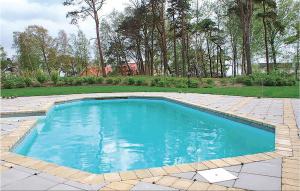 GlemmingeにあるBeautiful Home In Nybrostrand With 5 Bedrooms, Private Swimming Pool And Outdoor Swimming Poolの庭の青い水のスイミングプール