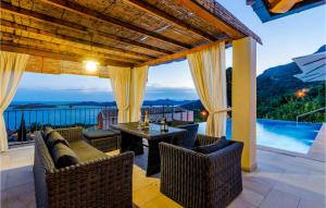 a patio with a table and chairs and a view of the ocean at Stunning Home In Brsecine With Outdoor Swimming Pool in Brsečine