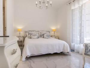 a white bedroom with a white bed and a chandelier at Lavish Villa in Mouans Sartoux with Sauna in Mouans-Sartoux