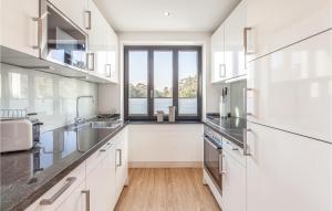 a kitchen with white cabinets and a large window at Pearl in Binz