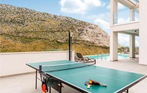 a ping pong table on the balcony of a house at Nice Home In Zrnovnica With Heated Swimming Pool in Žrnovnica