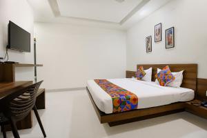 a bedroom with a bed and a television in it at FabExpress Comfort Stay I in Bhopal