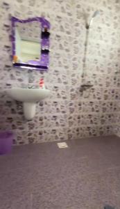 ein Badezimmer mit einem Waschbecken und einem Spiegel an der Wand in der Unterkunft بيت المقصورة بولاية سناو 