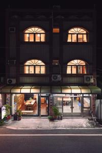 a tall building with windows and a building with a table at Carlos Backpacker in Minxiong