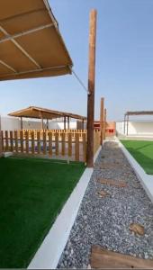 einen Hinterhof mit einem Zaun und grünem Gras in der Unterkunft بيت المقصورة بولاية سناو 
