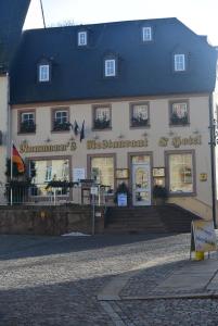 a large white building with a black roof at Naumann`s Hotel & Restaurant in Burgstaedt