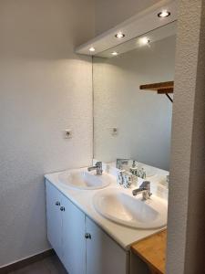 a bathroom with two sinks and a large mirror at ROOFTOP 3 CHAMBRES, TERRASSE, GARAGE in Vénissieux