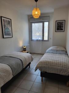 a bedroom with two beds and a window at ROOFTOP 3 CHAMBRES, TERRASSE, GARAGE in Vénissieux