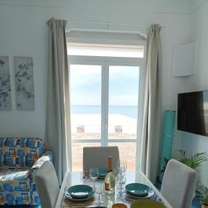 una sala da pranzo con tavolo e una grande finestra di Casa Emi ad Amalfi