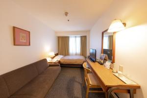 a hotel room with a couch and a bed at Nagaoka Grand Hotel in Nagaoka