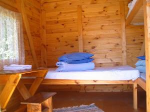 a bed in a log cabin with a wooden wall at Kõljala puhkeküla in Kaali