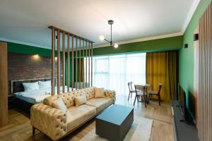 a living room with a couch and a bed and a table at The ONE Apart Hotel Luxury Suites & Apartments in Skopje