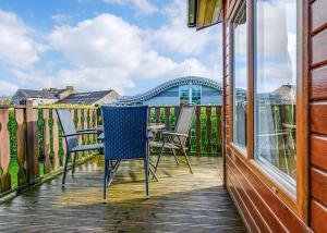 a deck with chairs and a table on a house at South Lakeland Leisure Village in Hornby