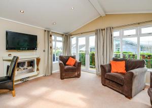 a living room with two chairs and a flat screen tv at South Lakeland Leisure Village in Hornby