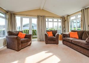 a living room with two couches and chairs and windows at South Lakeland Leisure Village in Hornby