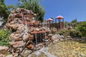 una cascada en un jardín con un estanque en Filippa Studios, en Plaka