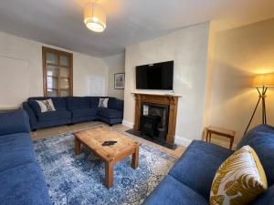 a living room with blue couches and a fireplace at The Hame in Monmouth