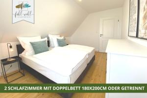 a bedroom with a bed with white sheets and blue pillows at Ferienhaus Fantaisie - Wohnen nahe Schlosspark -Stadtgrenze Bayreuth für 1-5 Pers, Hunde willkommen, voll eingezäunt in Eckersdorf