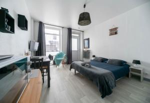 a bedroom with a bed and a table and a desk at Le Venise - appartement design - centre ville - parcs in Vichy