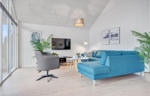 a living room with a blue couch and a table at Amazing Home In Jgerspris With Indoor Swimming Pool in Jægerspris