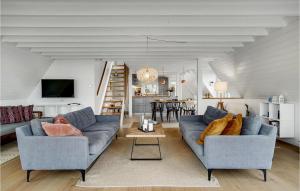 SkattebølleにあるNice Home In Tranekr With House Sea Viewのリビングルーム(青いソファ2台、テーブル付)
