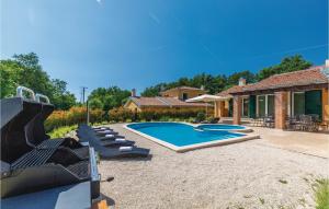 a swimming pool with lounge chairs and a house at Gorgeous Home In Rezanci With Jacuzzi in Režanci