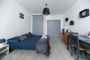 a bedroom with a blue bed and a table at Le Venise - appartement design - centre ville - parcs in Vichy +29 photos