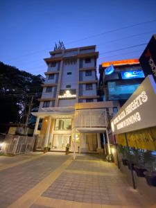 um edifício alto com um sinal em frente em Hotel Plaza Heights em Mangalore