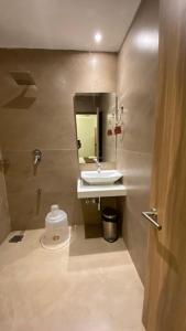 y baño con lavabo, espejo y aseo. en Hotel Plaza Heights, en Mangalore