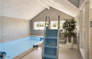 a swimming pool with blue seats in a house at Lovely Home In Idestrup With Wifi in Marielyst